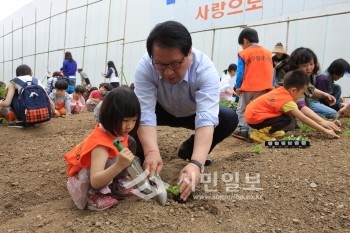 고재득 성동구청장이 어린이와 함께 꽃 모종을 심고 있다.